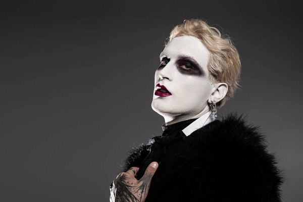 A young handsome man showcases his impressive Halloween costume with detailed makeup and style.