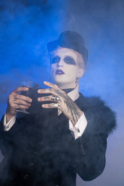 A young handsome man dressed in a striking Halloween costume showcases his creativity amidst fog.