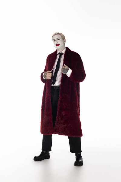 A young man showcases his Halloween spirit wearing an epic Joker costume, blending style and fun.