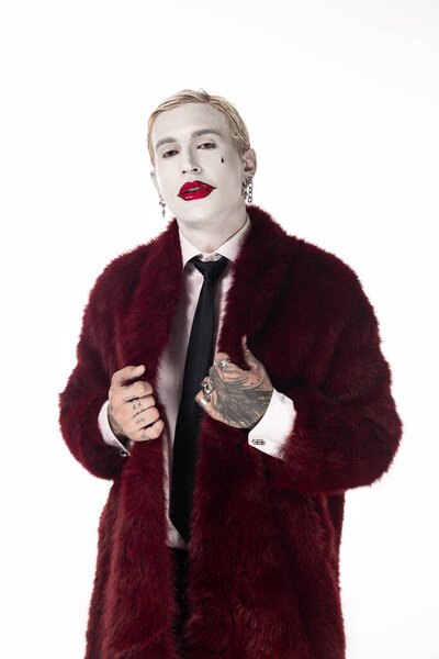 A handsome young man showcases his Joker costume, creating an unforgettable Halloween character.