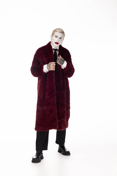 Handsome young man stunning in a Joker costume, ready for Halloween festivities with flair.