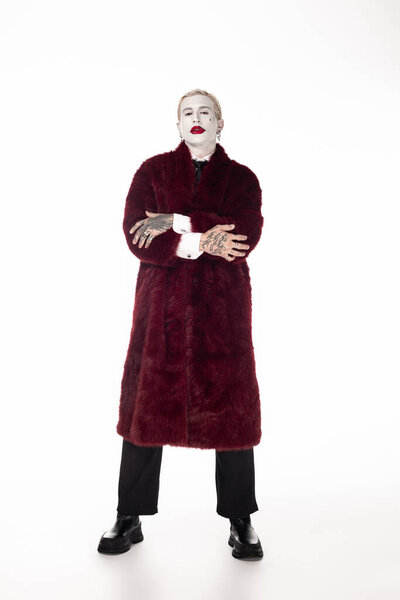 A young handsome man showcases his Joker costume with flair, ready for Halloween festivities.