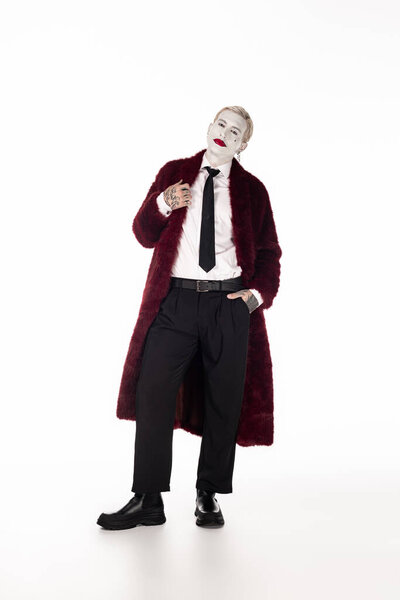 A young and handsome man showcases his impressive Joker costume during a Halloween event.