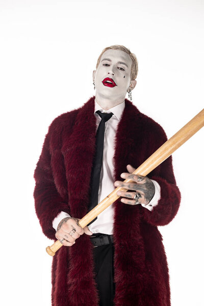 Young man dressed in a striking Joker costume showcases Halloween spirit with a playful demeanor.