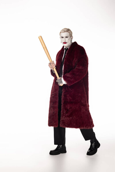 Handsome young man in a stunning Joker costume stands confidently, embodying Halloween spirit.