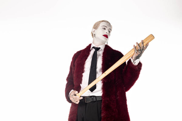 A handsome young man showcases his Joker costume this Halloween, holding a bat confidently.