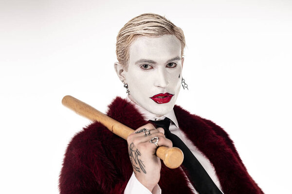 Молодой человек очаровывает толпу в потрясающем костюме Джокера, готового к празднованию Хэллоуина.