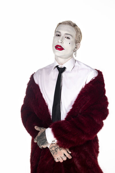 Young man rocks an epic Joker costume with striking makeup for Halloween.