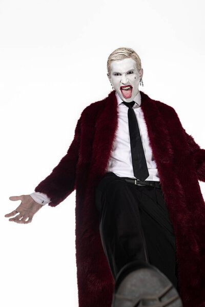 A young man showcases an impressive Joker costume, radiating excitement for Halloween festivities.