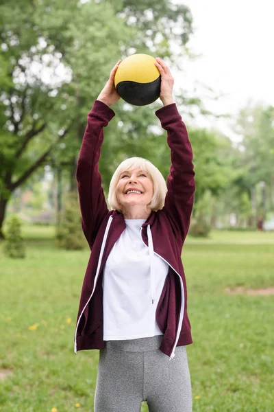 Sportif âgé faisant de l'exercice avec le ballon de médecine dans le parc vert — Photo de stock