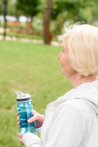 Старшая спортивная женщина держит спортивную бутылку с водой — стоковое фото