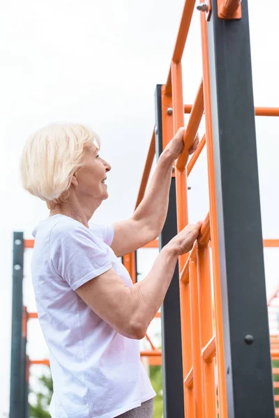 Senior sportswoman working out on sports ground — Stock Photo