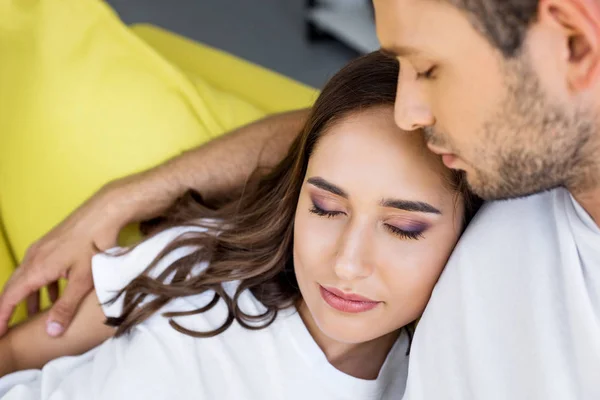 Nahaufnahme eines schönen glücklichen jungen Paares mit geschlossenen Augen, das sich zu Hause umarmt — Stockfoto