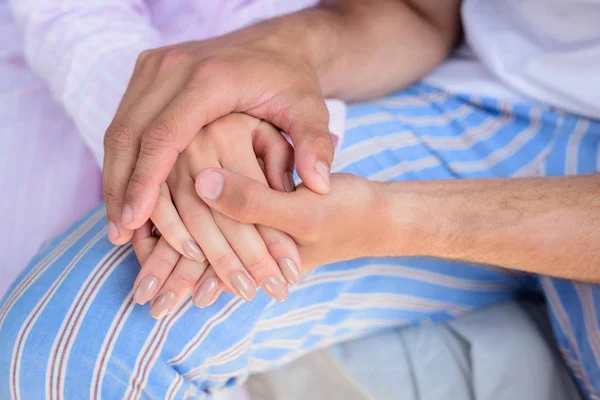 Partial view of young tender couple holding hands — Stock Photo