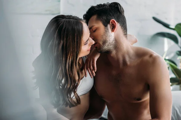 Sensual pareja besándose en cama en casa por la mañana — Stock Photo