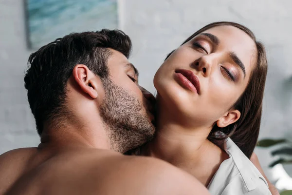 Novio besar sensual novias cuello en dormitorio por la mañana - foto de stock