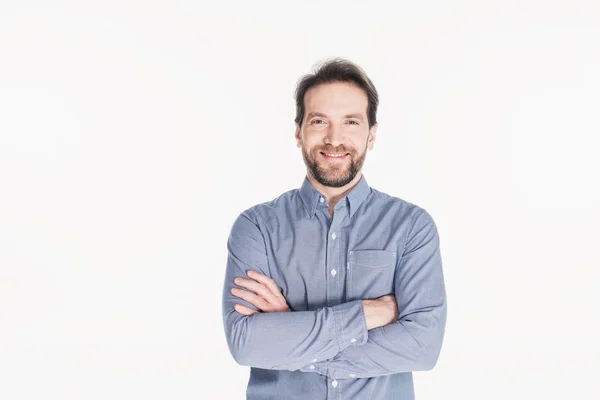 Ritratto di uomo barbuto sorridente con le braccia incrociate guardando la macchina fotografica isolata su bianco — Foto stock