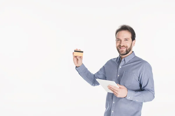 Retrato del hombre sonriente con la tableta digital que muestra la tarjeta de crédito aislada en blanco - foto de stock