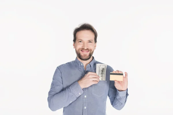 Portrait of smiling bearded man with dollar banknotes in pocket showing credit card in hand isolated on white — Stock Photo