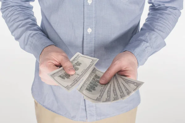 Tiro recortado de hombre contando billetes de dólar en mano aislados en blanco - foto de stock