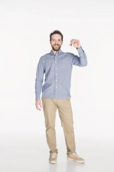 Sonriente hombre barbudo mostrando la llave de la nueva casa en la mano aislado en blanco - foto de stock