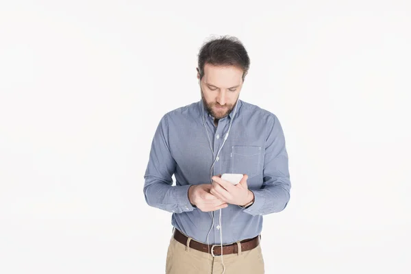 Retrato de homem em fones de ouvido usando smartphone isolado em branco — Fotografia de Stock