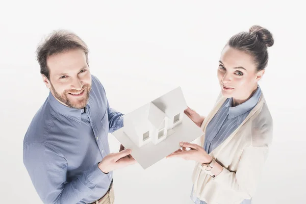 Visão de alto ângulo de casal segurando modelo de casa juntos isolado no branco — Fotografia de Stock