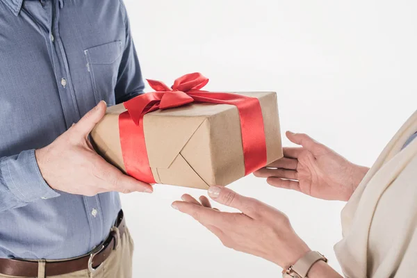 Vista lateral del hombre presentando regalo envuelto a la mujer aislado en blanco - foto de stock