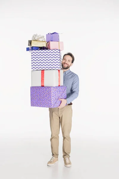 Hombre sonriente sosteniendo pila de regalos envueltos en manos aisladas en blanco - foto de stock