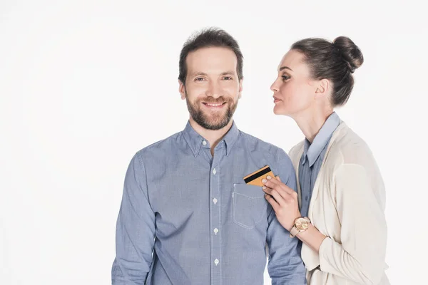 Portrait of woman taking credit card from husbands pocket isolated on white — Stock Photo