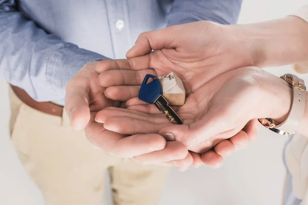 Vista parcial de la pareja sosteniendo la llave de nuevo hogar juntos - foto de stock