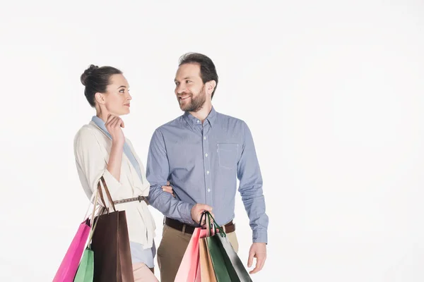 Retrato de casal alegre com sacos de compras isolados em branco — Fotografia de Stock