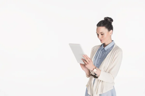 Vista laterale della donna in abbigliamento casual utilizzando tablet digitale isolato su bianco — Foto stock