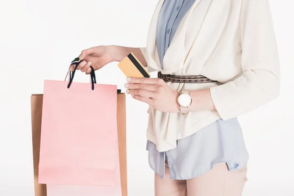 Tiro recortado de mulher com sacos de compras e cartão de crédito em mãos isoladas em branco — Fotografia de Stock