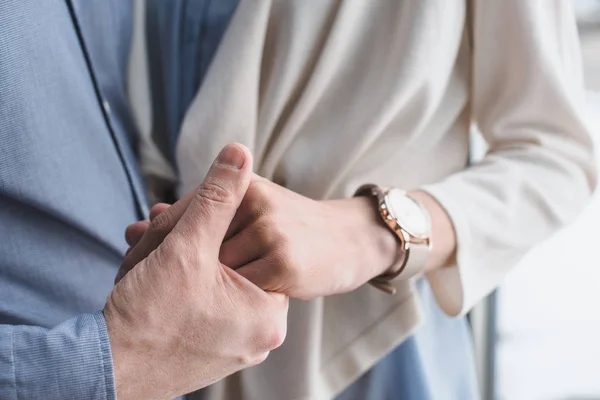 Partial view of wife and husband holding hands together — Stock Photo