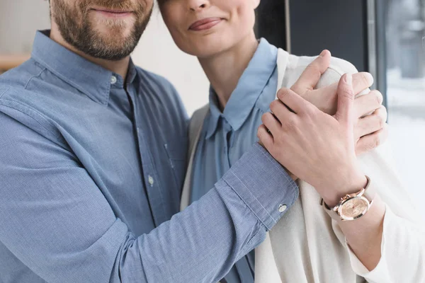 Teilansicht eines lächelnden Paares, das sich umarmt — Stockfoto