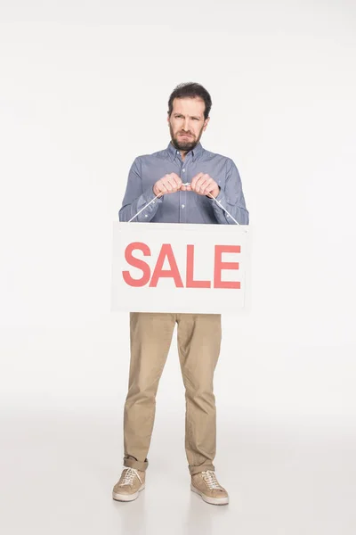 Homme bouleversé avec carte de vente isolé sur blanc — Photo de stock