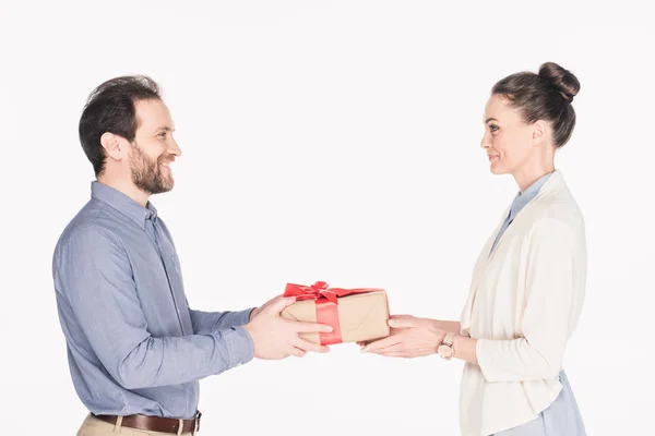 Вид збоку усміхненого чоловіка, який представляє загорнутий подарунок дружині ізольований на білому — стокове фото