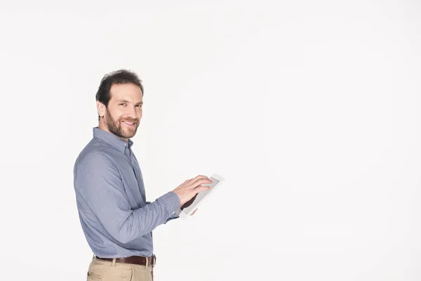 Вид сбоку улыбающегося человека с цифровой табличкой, изолированной на белом — стоковое фото
