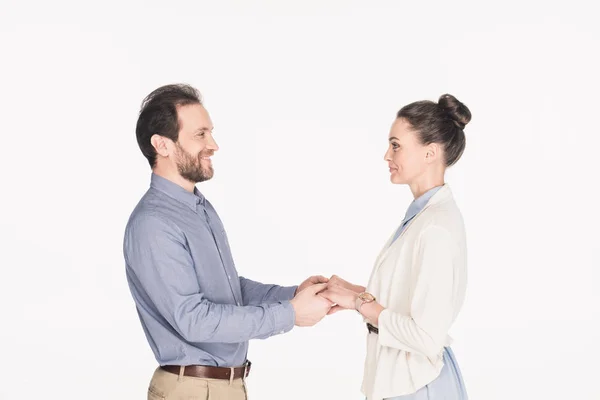 Seitenansicht der lächelnden Frau und des lächelnden Ehemannes, die sich vereinzelt auf Weiß die Hände halten — Stockfoto