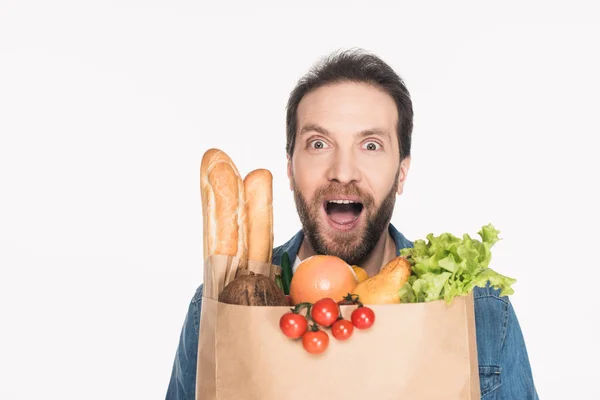 Portrait of excited bearded man with paper package full of food isolated on white — Stock Photo