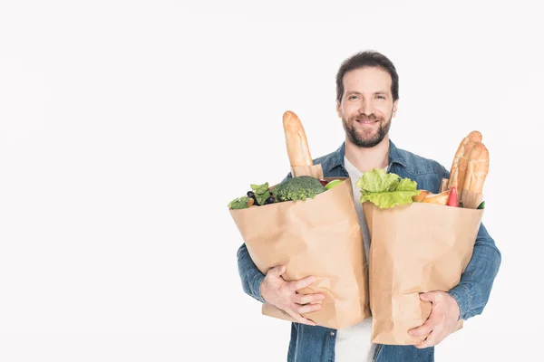 Porträt eines lächelnden Mannes mit Papierverpackungen mit Lebensmittelgeschäft isoliert auf weiß — Stockfoto