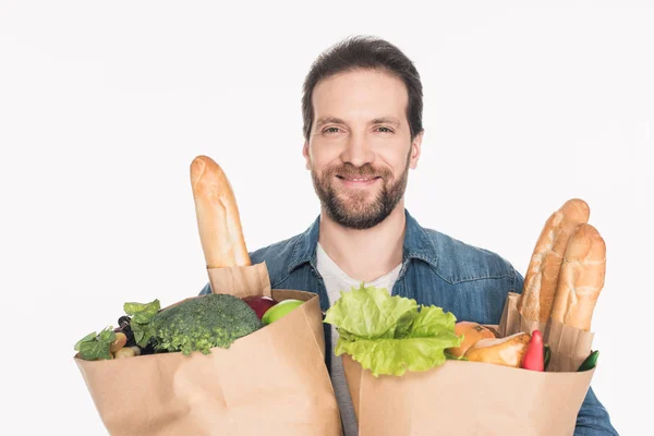 Ritratto di uomo sorridente con confezioni di carta piene di cibo isolato su bianco — Foto stock