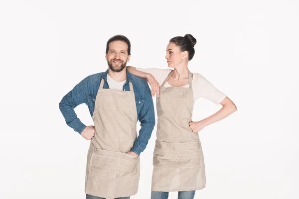 Portrait of man and woman in aprons isolated on white — Stock Photo