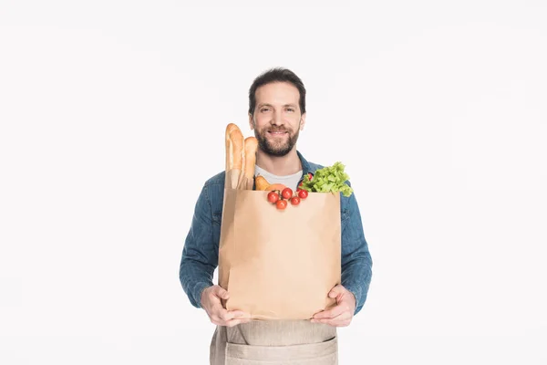 Porträt eines bärtigen Mannes in Schürze mit Papierverpackung mit Lebensmittelgeschäft isoliert auf weiß — Stockfoto