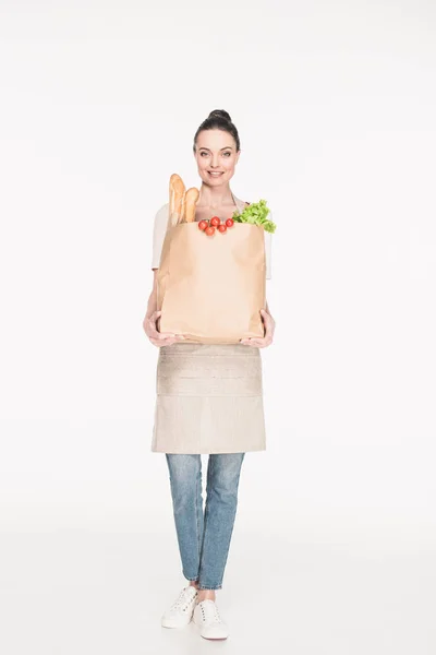 Femme dans le tablier tenant paquet de papier plein d'aliments isolés sur blanc — Photo de stock