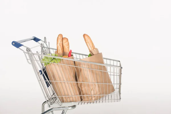 Close up view of shopping cart with paper packages full of grocery isolated on white — Stock Photo