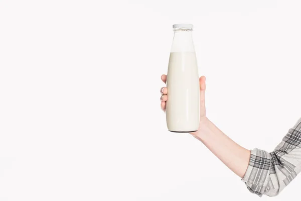 Tiro recortado de mujer sosteniendo botella de vidrio de leche aislada en blanco - foto de stock