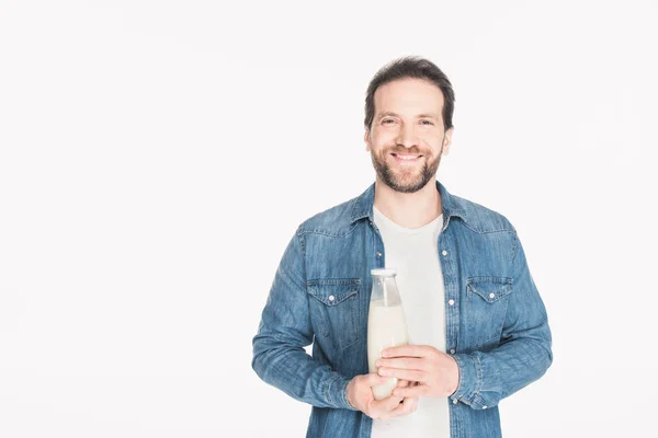 Retrato de hombre sonriente con botella de vidrio de leche en las manos mirando a la cámara aislada en blanco - foto de stock