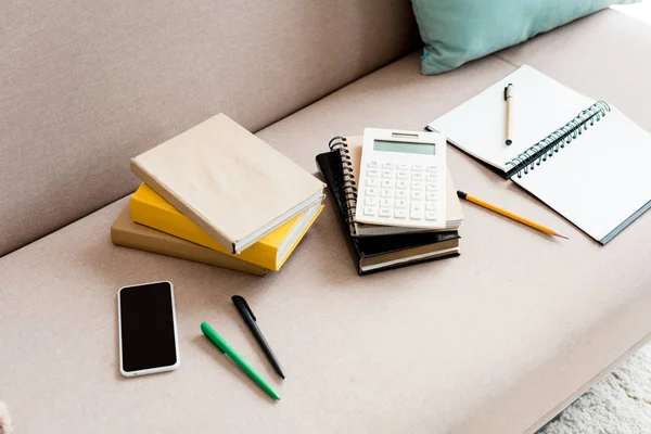 Gros plan des fournitures scolaires sur le canapé à la maison — Photo de stock